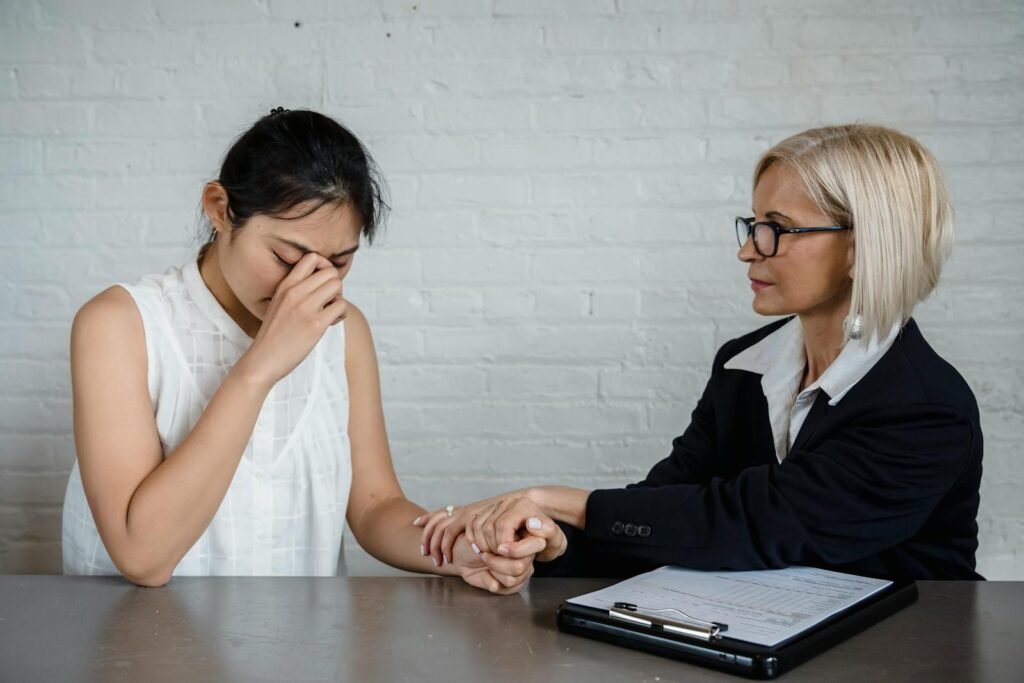 A therapist consoles a young woman dealing with Anxiety in a professional setting.